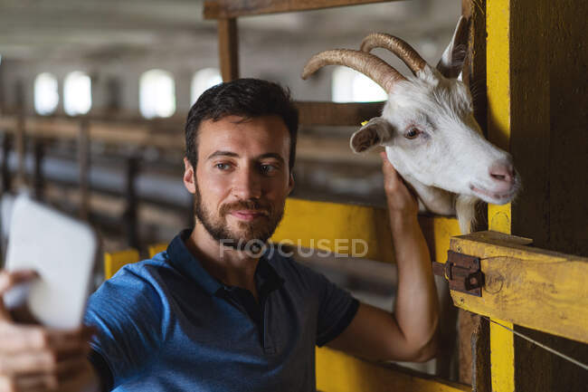 Guy takes a selfie on the phone with a goat — Stock Photo