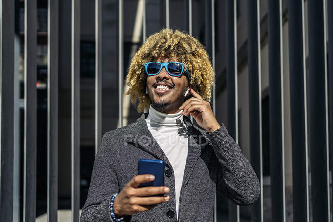 Bonito homem africano inteligente falando usando um telefone celular na rua. Conceito de comunicação — Fotografia de Stock