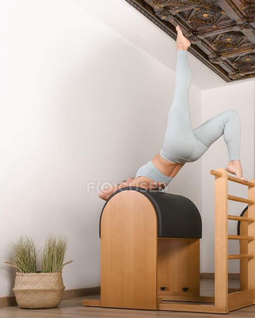Bruna ragazza fare il spalla ponte in un pilates classe oltre barile — Foto stock