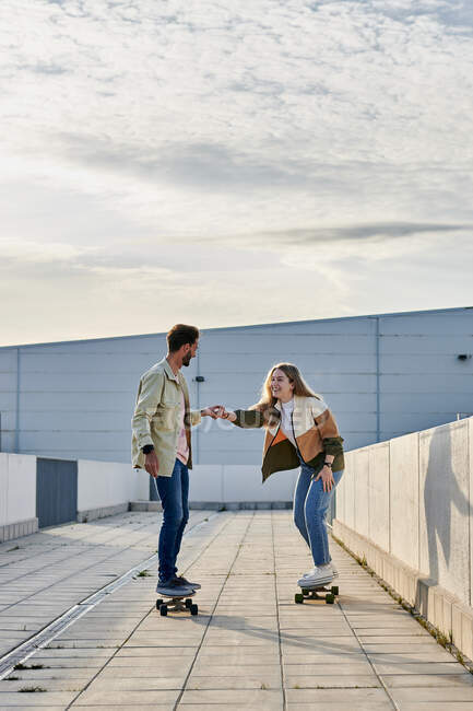 Jeune couple multiracial ayant du bon temps skateboard — Photo de stock