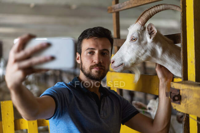 Ragazzo prende un selfie al telefono con una capra — Foto stock
