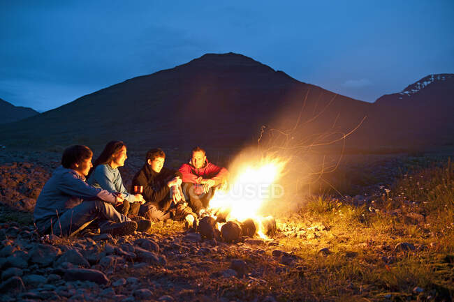Freunde sitzen am Lagerfeuer in Island — Stockfoto