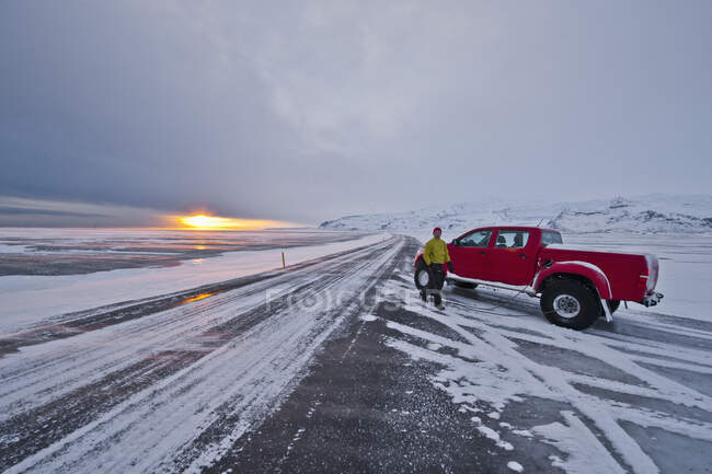 Pumping air into tyres on empty Icelandic road — Stock Photo