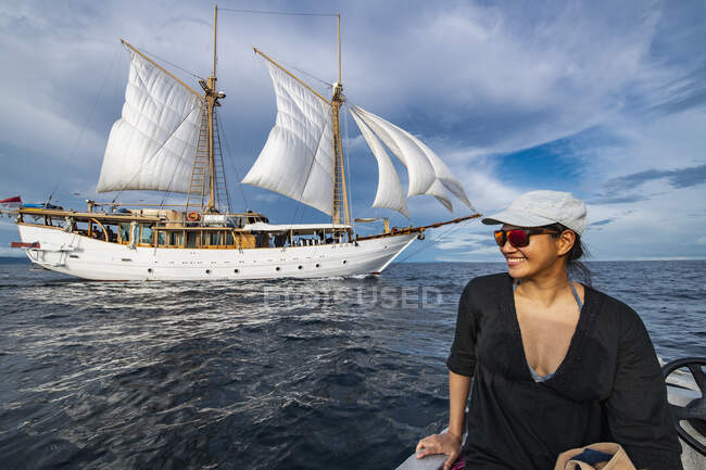 Mujer acercándose barco de vela en bote en Raja Ampat - foto de stock