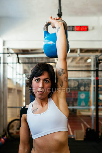 Сильная женщина использует гири в тренажерном зале — стоковое фото