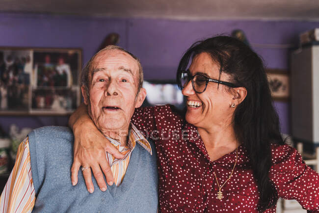 Portrait of a middle-aged daughter and her elderly father embracing. — Stock Photo