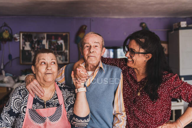 Портрет дочери средних лет и ее пожилых родителей, обнимающих и улыбающихся. — стоковое фото