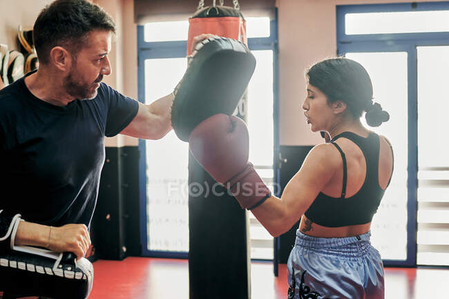 Молода жінка навчається з муай - тайським тренером у спортзалі. — стокове фото