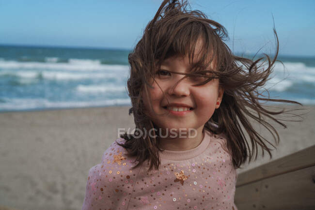 Girl against blue sky and ocean shore — Stock Photo