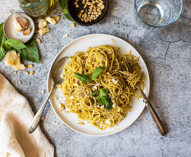 Italian pasta spaghetti with spinach sauce and basil on white stone table. top view. free space for your — Stock Photo