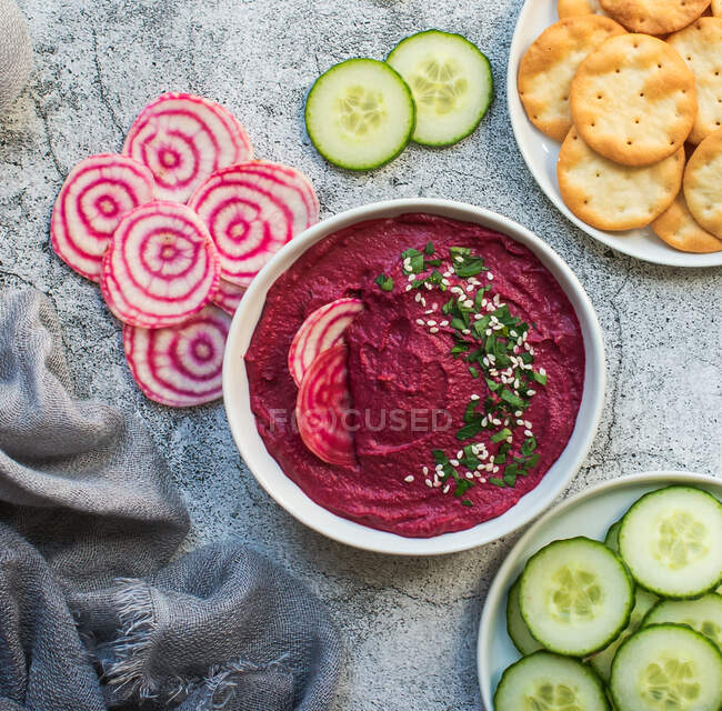 Cold beet soup with fresh vegetables and herbs in a bowl on a dark gray stone background. — Stock Photo