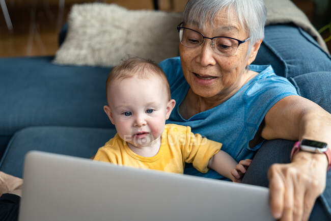 Senior mulher e neta fazendo videochamada através do laptop — Fotografia de Stock