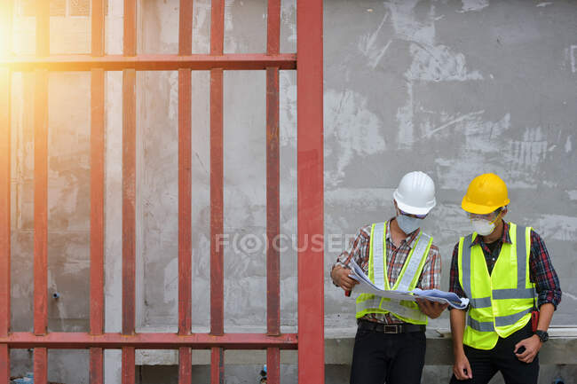 Engineer hold blueprint in hand and discussing project with buil — Stock Photo