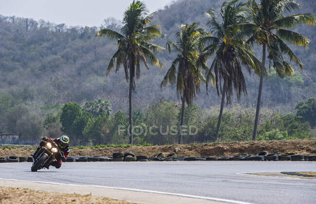 Человек на гоночной трассе со своим мотоциклом — стоковое фото