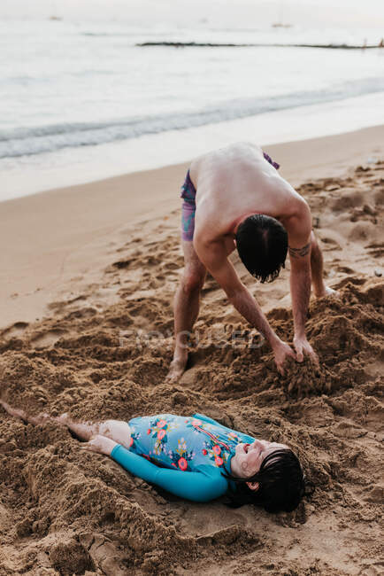 Father hurries daughter in the sand on a beach on Oahu, Hawaii — Stock Photo