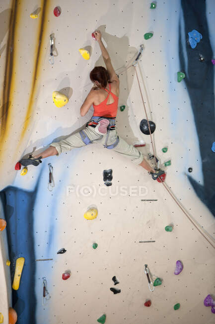 Femme escalade au mur d'escalade intérieur à Londres — Photo de stock
