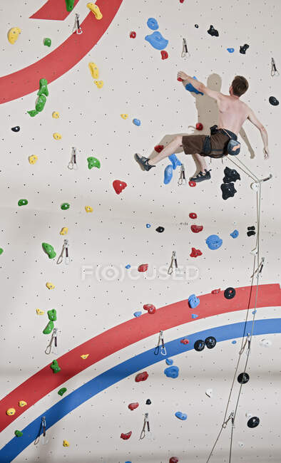 Hombre escalando en el muro de escalada interior en Londres - foto de stock
