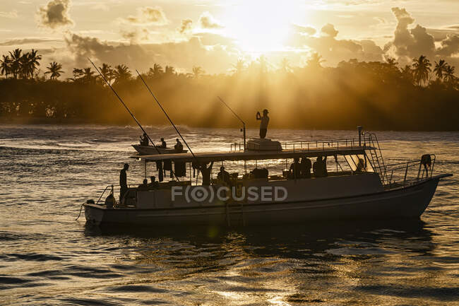 Bateau avec proche île tropicale au coucher du soleil — Photo de stock
