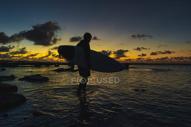 Surfista na costa oceânica ao pôr-do-sol — Fotografia de Stock