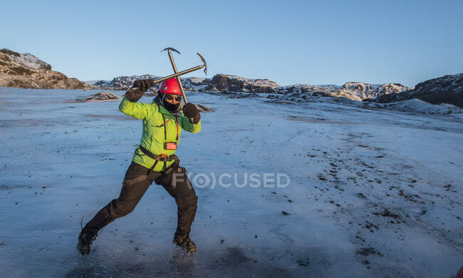 Mujer posando con picahielos en glaciar en Islandia - foto de stock