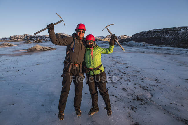 Пара позирует с ножом льда на леднике в Исландии — стоковое фото
