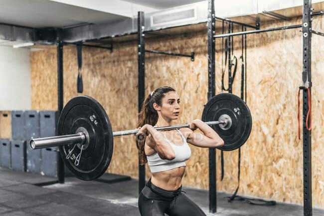 Woman with dumbbells in the gym doing crossfit — Stock Photo