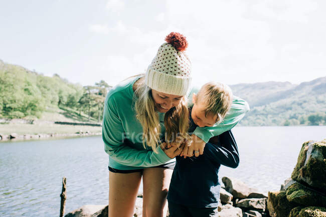 Mom hugging and laughing bonding with her son whilst on vacation — Stock Photo
