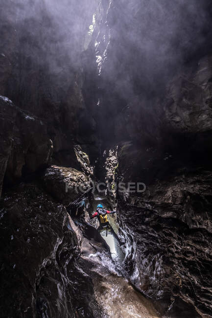 Niño desde atrás dentro de un cañón con aguas cristalinas - foto de stock