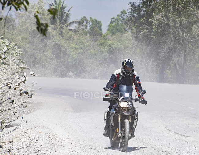 Чоловік їде на своєму пригодницькому мотоциклі по курній дорозі в Камбоджі. — стокове фото