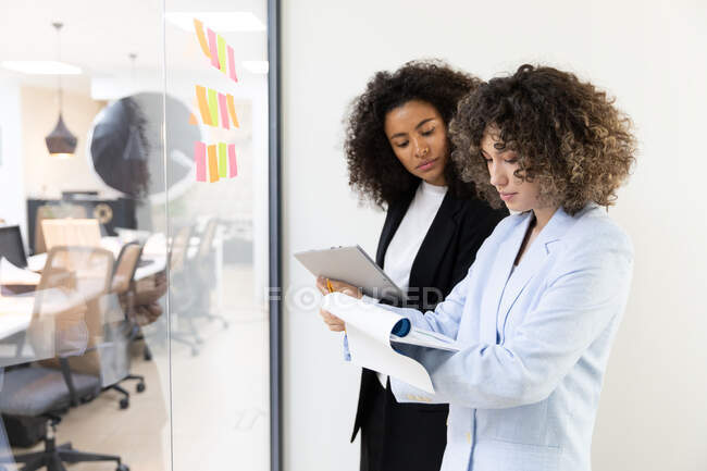 Multicultural coworkers using white board and doing brainstorming together. Co-working concept — Stock Photo