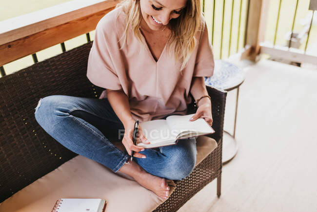Bella giovane donna che legge libro a casa — Foto stock