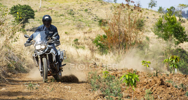Man riding his adventure motorbike on dirt road in Cambodia — Stock Photo