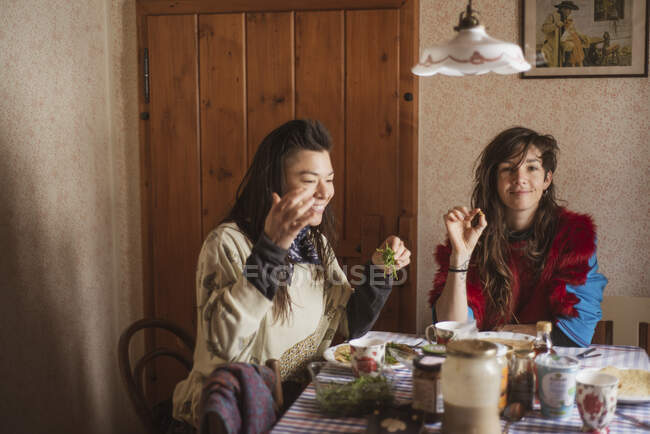 Queer weibliches Paar in bunten Kleidern frühstücken tschechische Hütte — Stockfoto
