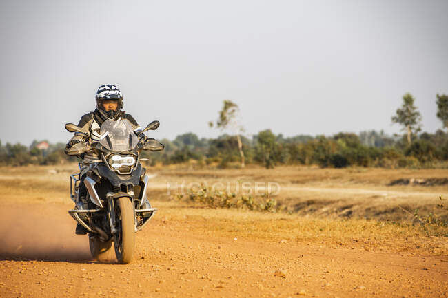 Uomo in sella alla sua moto avventura su strada sterrata in Cambogia — Foto stock