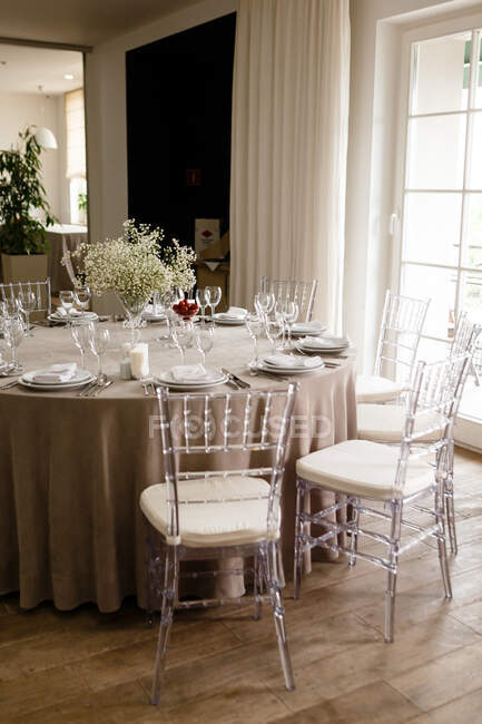 Bela mesa de casamento com flores brancas e pratos — Fotografia de Stock