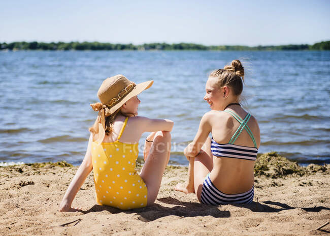 Две девочки-подростки в купальниках на берегу озера. — стоковое фото