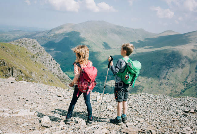 Niños en la cumbre del Monte Snowdon, Gales disfrutando de la hermosa vista - foto de stock