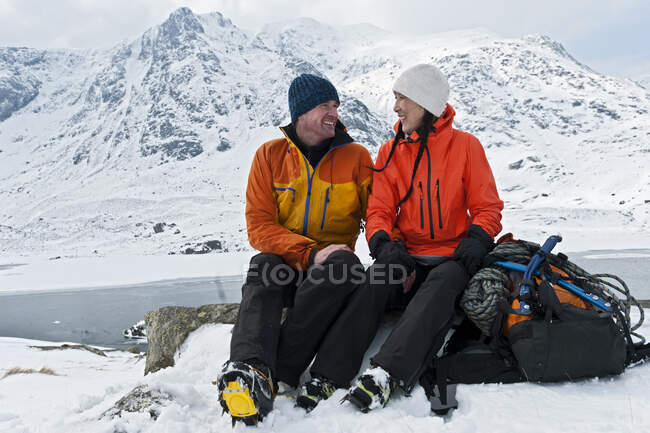 Couple se reposant sur une randonnée hivernale à Tryfan dans le nord du Pays de Galles — Photo de stock