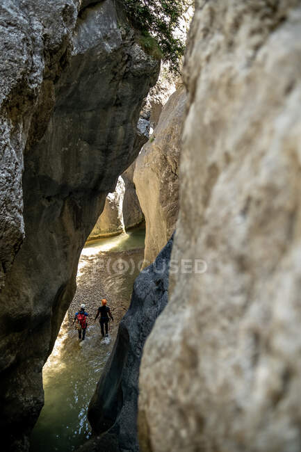 Vista lontana di 2 ragazze all'interno di un canyon con acqua — Foto stock