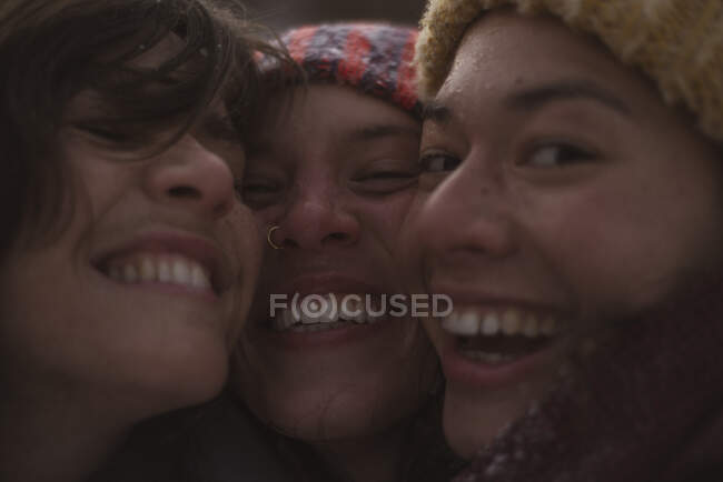 Three cute happy women laugh and smile for selfie in winter in europe — Stock Photo