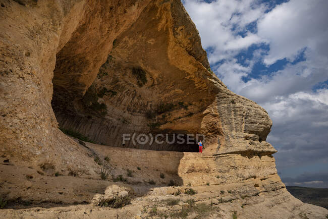 Una donna che cammina sotto un sentiero panoramico sotto un gigantesco strapiombo Grotte di Zaen, villaggio Zaen, Campo de San Juan, Moratalla, Regin de Murcia, Espaa — Foto stock