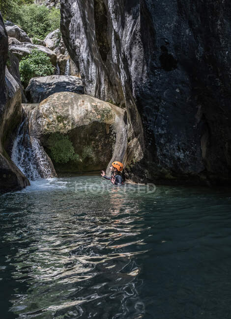 Vue grand angle d'un canyon avec fille canyoning dans l'eau — Photo de stock