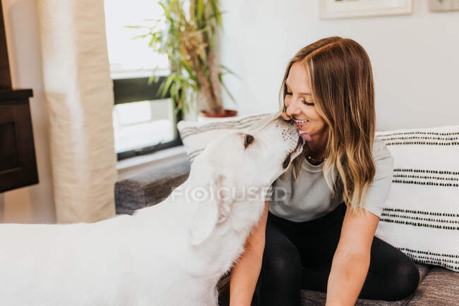 Young woman with her dog at home — Stock Photo