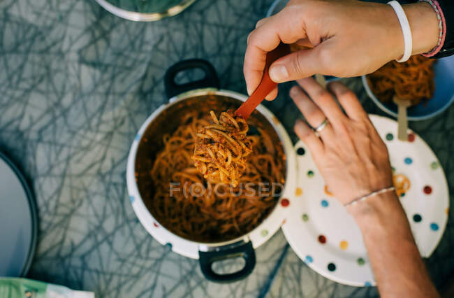Mulher com espaguete em uma panela, close up — Fotografia de Stock