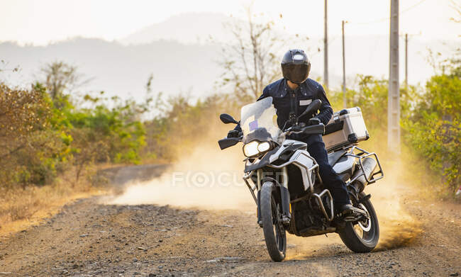 Mann fährt mit seinem Abenteuer-Motorrad auf Feldweg in Kambodscha — Stockfoto
