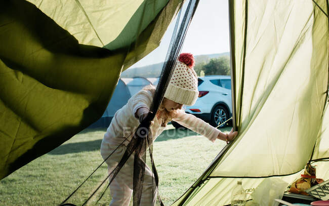 Mädchen steigt im Urlaub in ihr Familienzelt auf einem Campingplatz — Stockfoto
