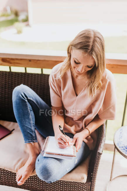 Красива молода жінка робить нотатки вдома — стокове фото