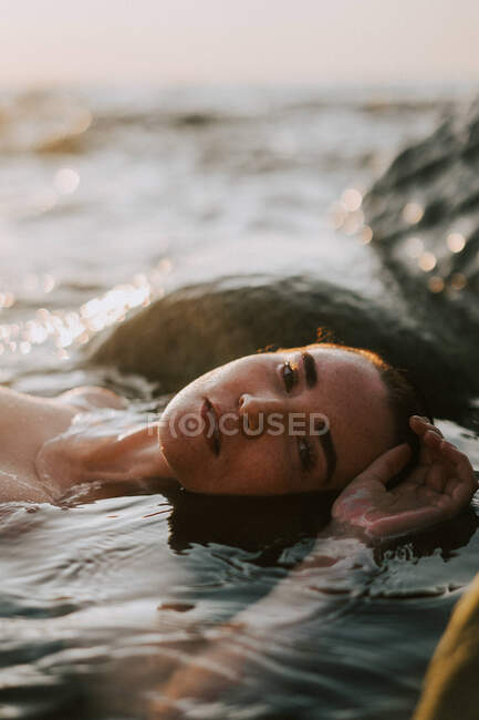 Junge Frau liegt im Ozean — Stockfoto