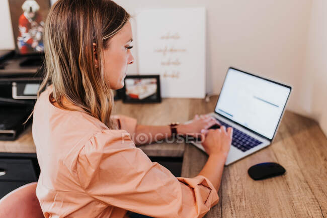 Young woman working on laptop in office — Stock Photo