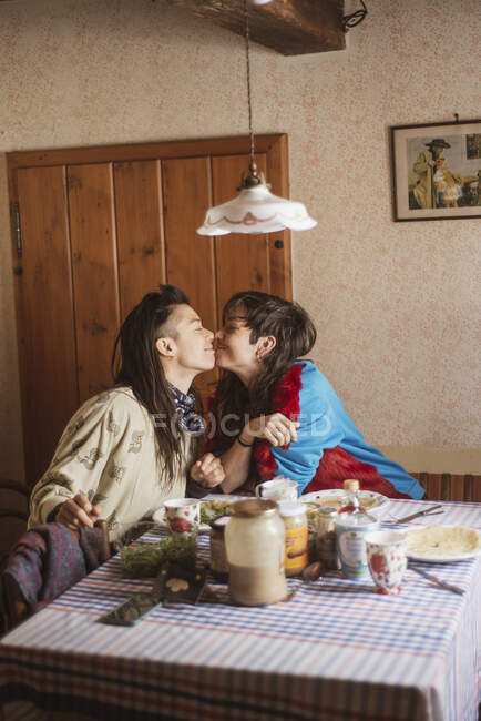 Queer couple féminin sourire et baiser pendant le petit déjeuner d'anniversaire en Tchétchénie — Photo de stock